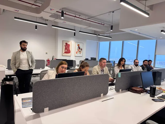Team of professionals working at computer workstations in a modern office